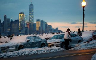 Moradores limpam carros cobertos de neve em Weehawken, New Jersey